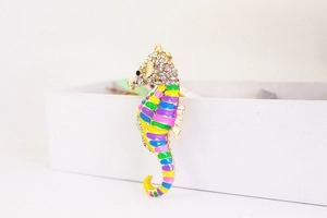 Detail of colorful enamel seahorse keychain with sparkling white rhinestones and gold plating