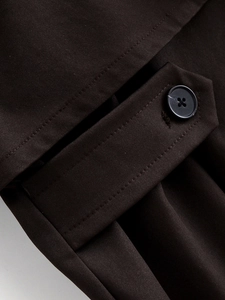 Macro di tessuto twill marrone cioccolato fondente con bottone nero sulla patta della tasca