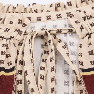 Close-up of drawstring waist detail and vibrant geometric print on a long dress