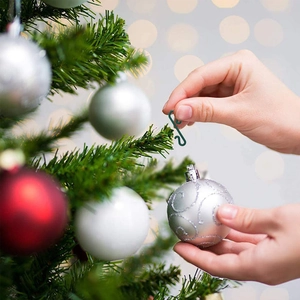 Green S-shaped hook for hanging silver Christmas tree ornaments and festive decorations