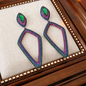 Detail of vintage flower earrings featuring emerald and sapphire pavé settings