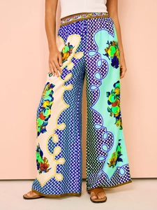 Detailed view of vibrant tropical print wide-leg trousers with elastic high waist