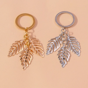Hollow leaf alloy keychain set in gold and silver finish on neutral background