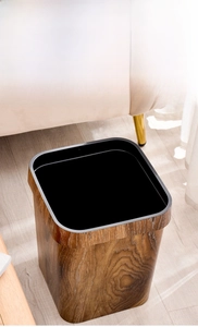 Gros plan d'une poubelle carrée avec une finition imitation bois naturel dans un salon