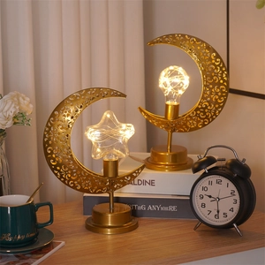 Lampes de table dorées en forme d'étoile et lune avec guirlandes LED sur un bureau