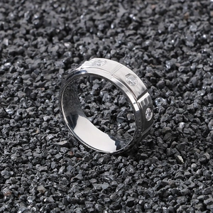 Detail of 8mm silver titanium ring with three inset diamonds on black volcanic stone