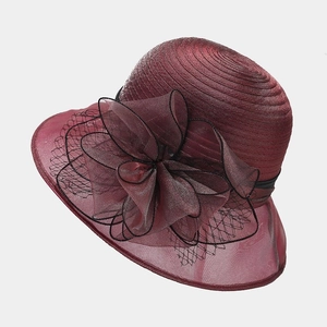 Detail of burgundy organza floral fascinator with mesh bow and woven brim texture