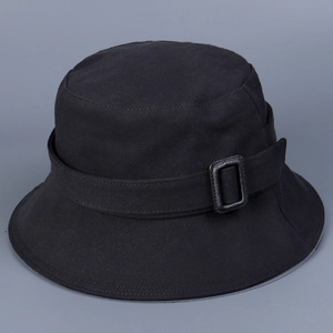 Detailed view of black cotton bucket hat featuring a decorative strap and matte square buckle