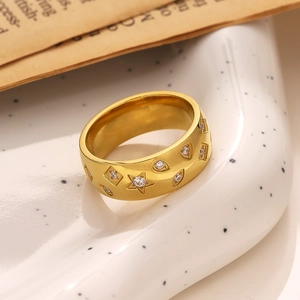 Close-up of 18k gold plated stainless steel ring with zircon stars on vintage paper