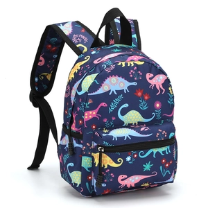 Detail view of the 13 inch blue backpack featuring colorful cartoon dinosaur prints