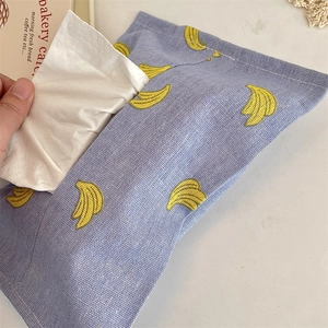 Close-up of a light blue tissue box cover with banana print on a linen textured fabric