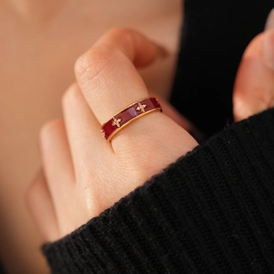 Detailed macro of vintage red enamel ring with gold beads and sparkling zircon stars