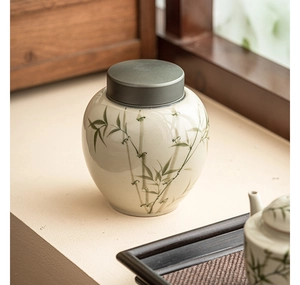 Detailed close-up of ceramic tea canister featuring green bamboo art and alloy lid