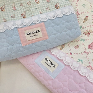 Detailed view of quilted cotton tote bag featuring heart patterns and lace trim details