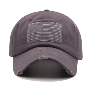 Detailed view of the distressed cotton fabric and American flag patch on a tactical cap