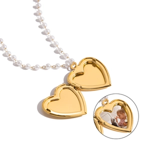 Detail of an open gold heart locket necklace with pearl chain for photos