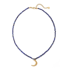 Detail of vintage necklace with blue faceted beads and a golden crescent moon pendant