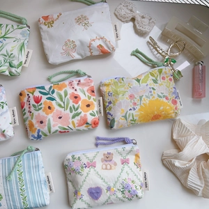 Detailed close-up of floral cotton mini pouches with zipper and carry strap