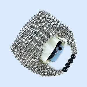 Detailed top view of silver beaded handbag with black bead accents and silk lining pouch