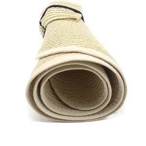 Detail of rolled beige straw hat showing flexible weave and portable foldable design