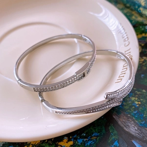 Detail of silver bangles with sparkling cubic zirconia on a minimalist ceramic plate