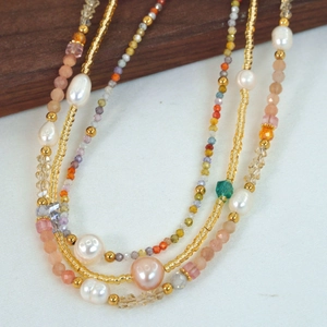 Close-up of handmade multilayer necklace with freshwater pearls and colorful gemstones
