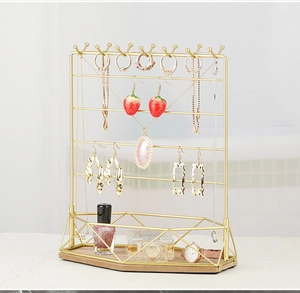 Detail of gold metal jewelry organizer with wooden base for necklaces and earrings