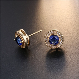 Detailansicht der goldfarbenen Ohrstecker mit blauem Saphir und Mikro-Pave-Kristallen