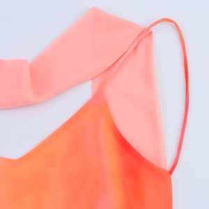 Close-up of coral orange silk dress featuring delicate straps and shimmering gradient fabric