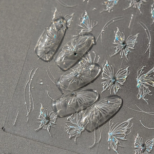 Detailed macro view of 3D aurora white butterfly nail stickers with embossed pearl patterns