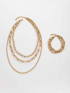 Flat lay of gold layered paperclip chain necklace and woven bracelet set on white background