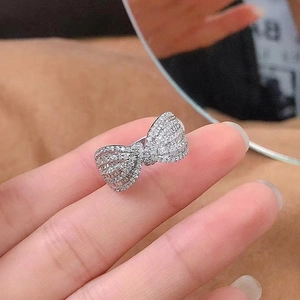 Macro detail of a silver bow ring featuring micro-paved white cubic zirconia stones