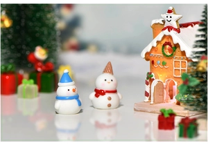 Illuminated resin gingerbread house with cute snowman miniatures for Christmas decor