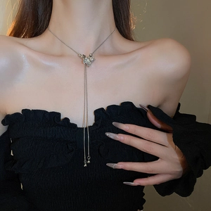 Silver butterfly tassel necklace on model with black dress showing elegant drape