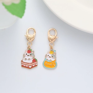Detail of cute cat charms on strawberry cake and honey jar with golden heart clasps