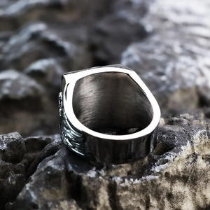 Macro detail of punk skull signet ring featuring side wing relief and brushed metal finish