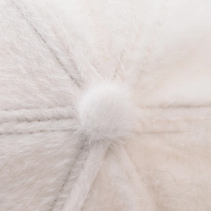 Macro shot of fluffy cream-white faux rabbit fur texture and top stitch on baseball cap