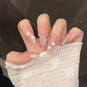 Detail of pink pearl press-on nails with 3D floral accents and gradient cat-eye finish