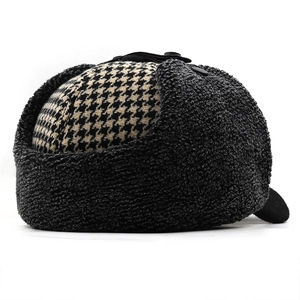 Detailed side view of winter trapper hat featuring houndstooth pattern and fleece earflaps