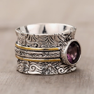 Detail of vintage textured ring with floral engraving and round purple gemstone inlay