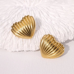 Pair of minimalist golden heart stud earrings with textured rib design on white background