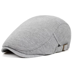 Detail of light gray flat cap with side metal buckle and soft textured fabric