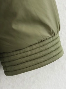 Detailansicht der olivgrünen Jacke mit Rippbündchen und hochwertiger Stoffbeschaffenheit