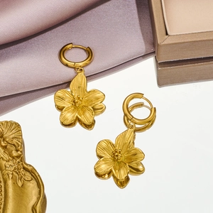 18K gold plated flower drop earrings made of stainless steel on mirror with reflection