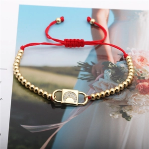 Red cord bracelet with golden moon zircon lock charm and beads on high quality photo background