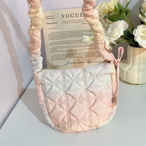 Macro detail of pink gradient quilted cloud bag with pleated strap and soft fabric texture