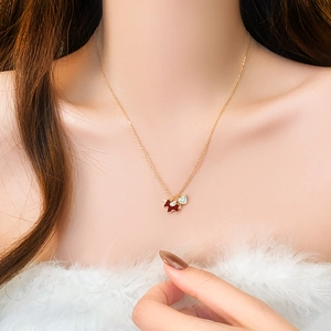 Close-up of gold-plated pony necklace with red star and sparkling zircon heart pendant