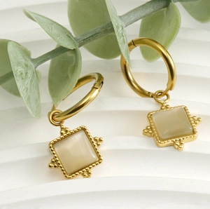 Close-up of vintage square cat-eye stone earrings in gold finish with beaded edges