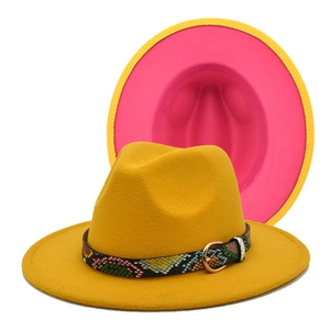 Detail of yellow and magenta fedora hat with a colorful snakeskin pattern belt buckle