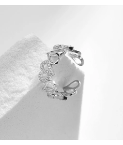 Macro detail of 925 sterling silver heart ring with small crystals on white stone